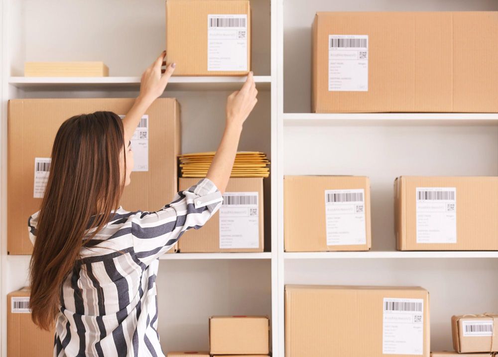 Woman organizing boxes for international shipping